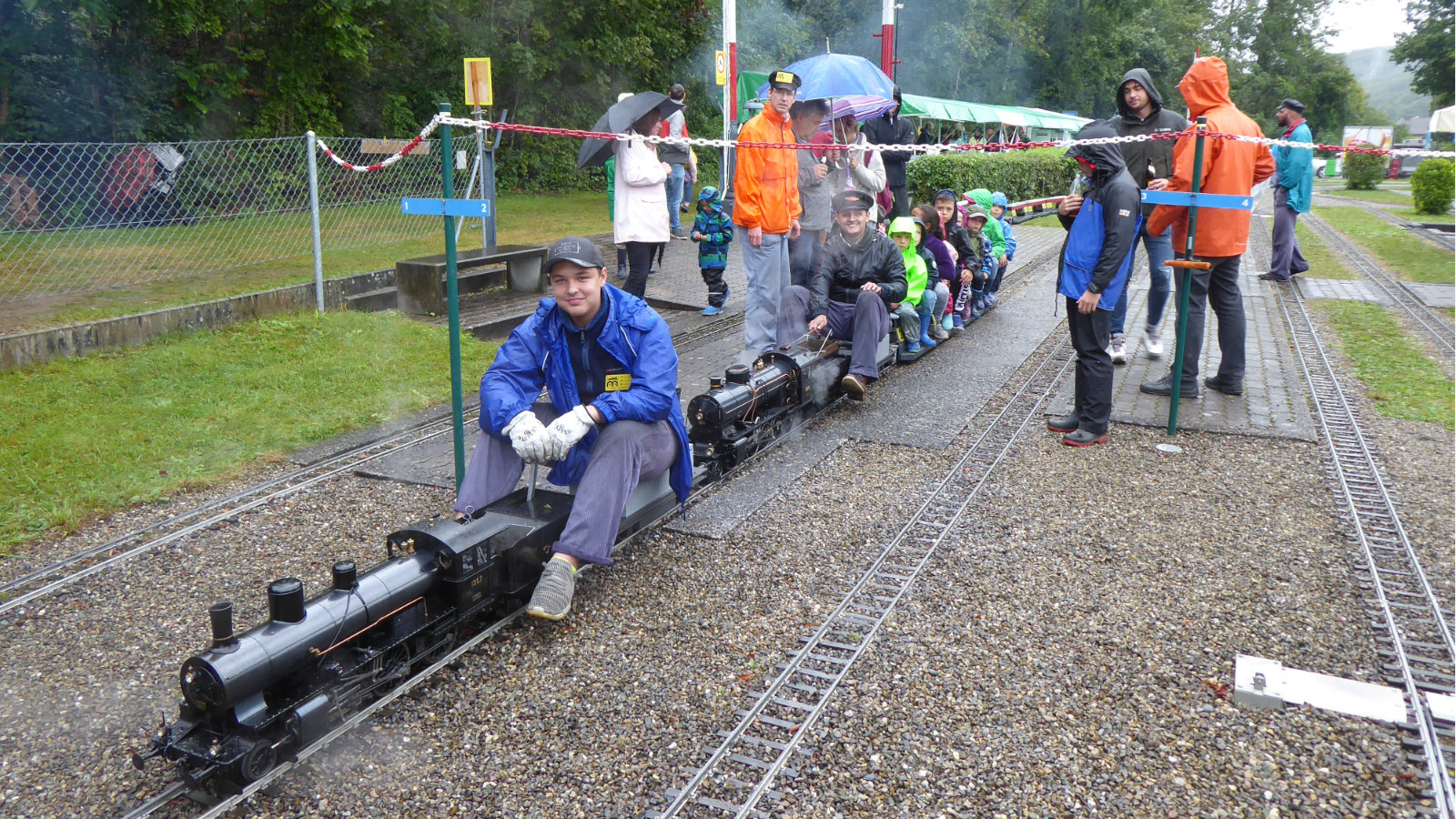 trotz Dauerregen ein Lächeln im Gesicht: Lokomotivführer der Dampflokomotiven